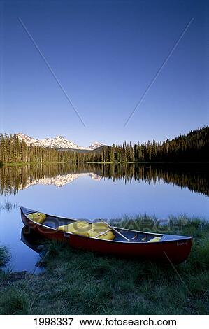 Stock Photo - Oregon, Cascade Mountains, Canoe At Scott Lake, Three Sisters Mountain Reflections Background B1657. Fotosearch