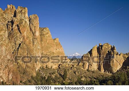Oregon, Cliffs At Smith Rock State Park With Mount Jefferson Visible Through Asterisk Pass. View Large Photo Image Stock Image - Oregon, Cliffs At Smith Rock State Park With Mount Jefferson Visible Through Asterisk Pass.. Fotosearch