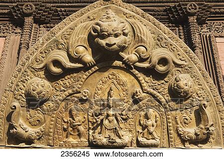 Stock Photography - Ornate metal carving hangs above the entrance to Minanath Temple, dating from the Licchavi period; Bhaktapur, Nepal. Fotosearch