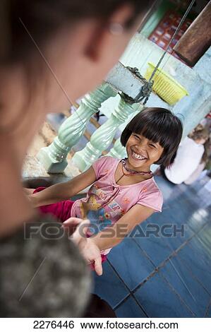 Stock Photograph - Orphan children from The Nun's School or Karen Refugee Orphanage (Pimjai Nun Temple) run by a buddhist nun and a popular student gap year volenteer experience; Sangkhla Buri, Kanchanaburi, Thailand. Fotosearch