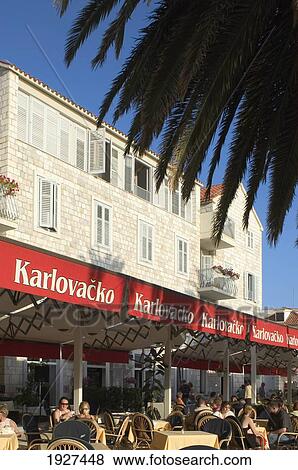 Stock Photo - Outdoor Cafe Under Palm Tree In Hvar Town; Hvar, Split-Dalmatia County, Croatia. Fotosearch