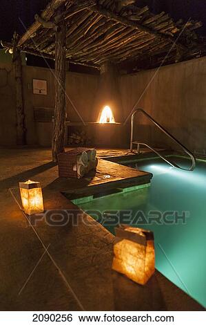 Stock Photograph - Outdoor Spa Pool At Night With A Kiva Fire In Ojo Caliente Mineral Springs Is A Northern New Mexico Resort And Spa Near Santa Fe. Fotosearch