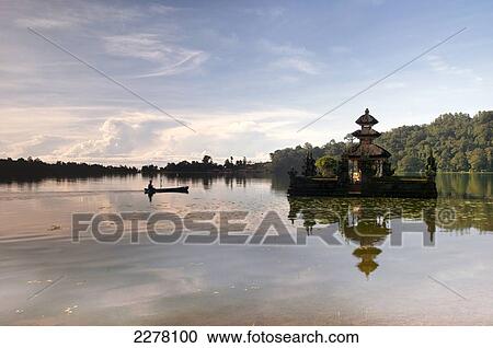 Stock Image - Outrigger canoe and temple on Lake Bratan; Bali. Fotosearch