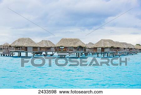 Stock Photo - Over-water bungalows at a tropical resort; Bora Bora, French Polynesia. Fotosearch