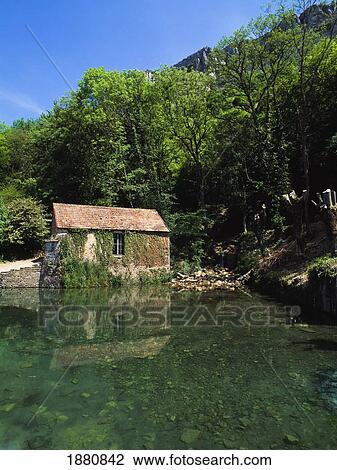 Stock Image - Overgrown Cottage By The Lakeside.. Fotosearch