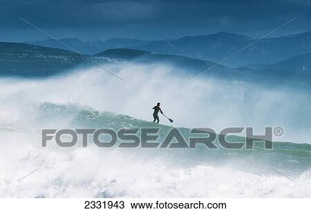 Stock Image - Paddleboarding In The Waves Along The Coast Of Cape Trafalgar; Cadiz, Andalusia, Spain. Fotosearch