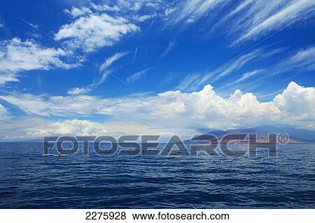 Stock Photo - Paddleboarding off the coast of an hawaiian island; Hawaii, United States of America. Fotosearch