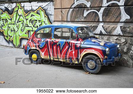 Stock Image - Painted Fiat 600 next to a mural, Sarajevo, Bosnia and Herzegovina. Fotosearch