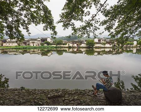 Stock Photo - Painter by Nanhu Lake, Hongcun, Anhui, China. Fotosearch