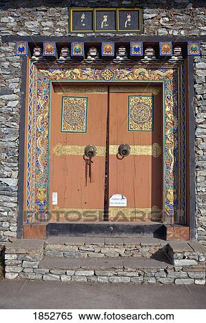 Stock Photography - Painting On Doorway In Rock Wall, Bhutan. Fotosearch