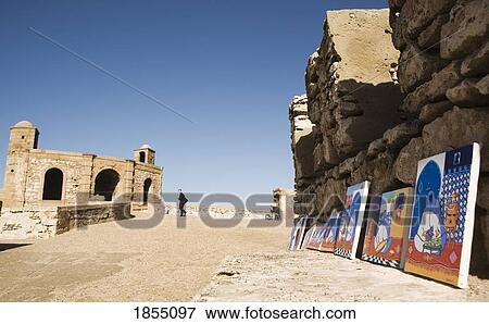 Stock Photo - Paintings Leaning Against City Wall, Essaouira, Morocco. Fotosearch