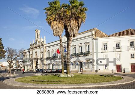 Stock Photo - Palm Trees In The Centre Of A Traffic Circle With A White Building Behind; Faro Algarve Portugal. Fotosearch