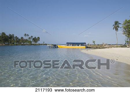 Stock Image - Panama, San Blas Islands (also called Kuna Yala Islands), Yandup Island, small beach with boat at the dock.. Fotosearch