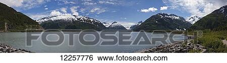 Stock Photograph - Panorama of Portage Lake and the surrounding mountains and glaciers, Portage Valley, Southcentral Alaska, Summer. Fotosearch