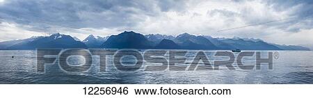 Stock Photograph - Panoramic scenic of Resurrection Bay and Kenai Mountains on a cloudy day, Southcentral Alaska, Summer. Fotosearch