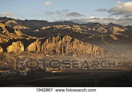 Panoramic View Of Bamiyan And The Escarpment With Hundreds Of Caves And The Niche That Contained The Small Buddha Statue Destroyed By The Taliban In 2001, Bamian Province, Afghanistan View Large Photo Image Stock Photo - Panoramic View Of Bamiyan And The Escarpment With Hundreds Of Caves And The Niche That Contained The Small Buddha Statue Destroyed By The Taliban In 2001, Bamian Province, Afghanistan. Fotosearch