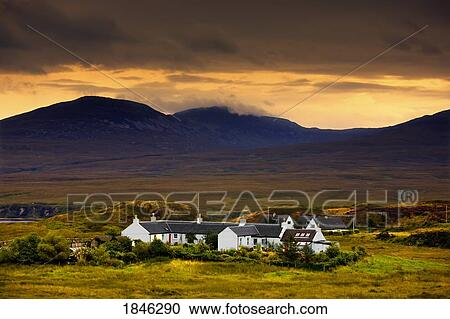 Stock Image - Paps Of Jura, Jura, Scotland; Houses With Mountain Backdrop. Fotosearch