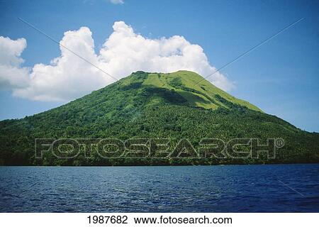 Stock Image - Papua New Guinea, Mother Volcano and green mountainside with ocean and clouds; Rabaul. Fotosearch