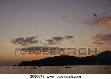 Stock Photo - Paraglider At Sunset Descending Over Oludeniz In The Turquoise Coast, Southern Turkey. Fotosearch