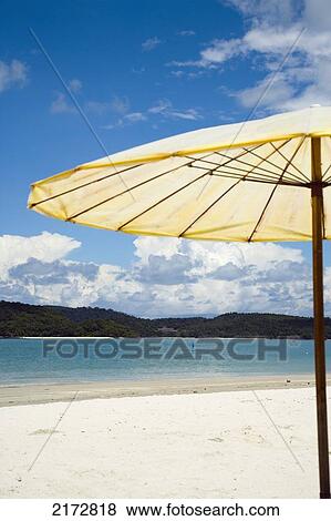 Stock Photo - Parasol On Beach Overlooking Sea With Small Island In Backgroundpantai Cenang (Cenang Beach), Pulau Langkawi, &#10; Malaysia, South East Asia.. Fotosearch