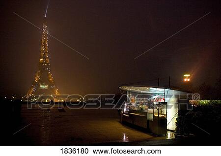 Stock Image - Paris, France; Eiffel Tower Lit Up At Night With Refreshment Stand In The Foreground. Fotosearch