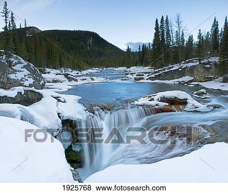 Partially Frozen Waterfall In The Canadian Rockies; Bragg Creek, Alberta, Canada View Large Photo Image Stock Photo - Partially Frozen Waterfall In The Canadian Rockies; Bragg Creek, Alberta, Canada. Fotosearch