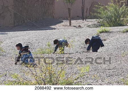 Stock Image - Pashtun Boys Picking Up Gravel, Khyber Pass, Federally Administered Tribal Areas, Pakistan. Fotosearch