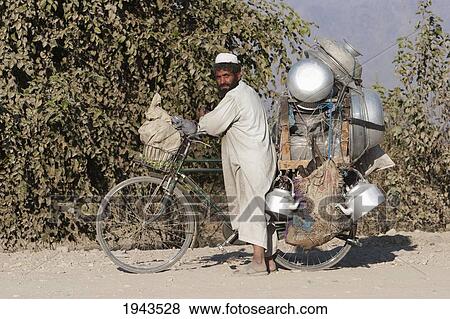 Pashtun Man Carrying His Restaurant On A Bicycle On The Torkham To Jalalabad Road, Nangarhar Province, Afghanistan View Large Photo Image Stock Photo - Pashtun Man Carrying His Restaurant On A Bicycle On The Torkham To Jalalabad Road, Nangarhar Province, Afghanistan. Fotosearch