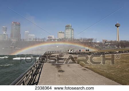 Pathway Near Niagara Falls With Rainbow, Skyline Towers And Blue Sky In Background; Niagara Falls, New York, United States Of America View Large Photo Image Picture - Pathway Near Niagara Falls With Rainbow, Skyline Towers And Blue Sky In Background; Niagara Falls, New York, United States Of America. Fotosearch
