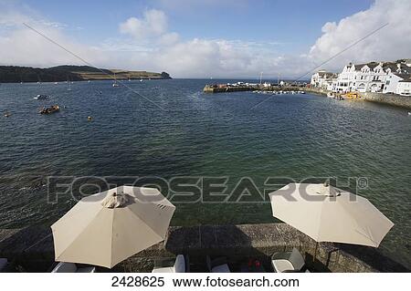 Stock Photography - Patio with umbrellas and a view of the shoreline of Roseland Peninsula; St. Mawes, Cornwall, England. Fotosearch