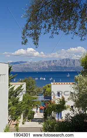 Stock Image - Paved Footpath Between Houses Overlooking Sea, Lefkas, Ionian Islands, Greece. Fotosearch