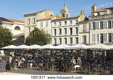 Stock Photo - Pavement cafes outside in square, Rochefort, Rochefort, Charente-Maritime department of the Poitou-Charentes region of France.. Fotosearch