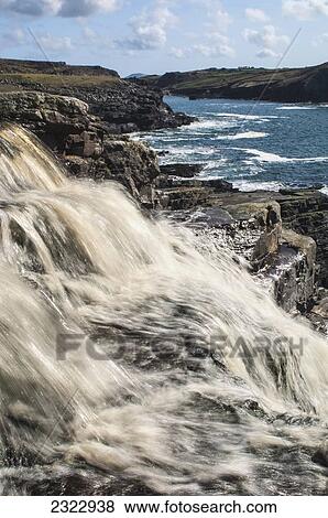 Stock Photo - Peat colored water pouring into Cooncrome Harbor; Cahersiveen, County Kerry, Ireland, UK. Fotosearch