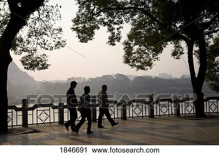 Stock Image - Pedesrians In Waterfront District; Guilin, Guangxi Province, China. Fotosearch