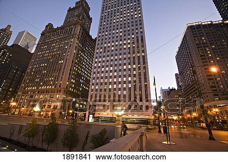 Stock Image - Pedestrian And Street Traffic At Downtown Intersection At Dusk. Fotosearch