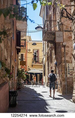 Picture - Pedestrian in an alley in old town; Chania, Crete, Greece. Fotosearch