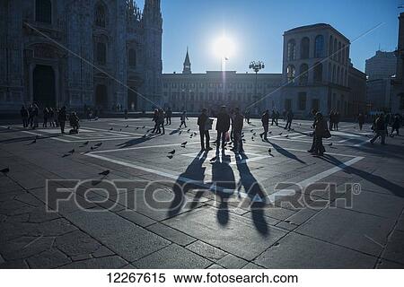 Stock Photography - Pedestrians and birds outside Milan Cathedral; Milan, Lombardy, Italy. Fotosearch