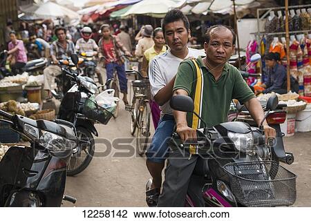 Pedestrians and motorcycle riders on the street in Luh Market; Siem Reap, Cambodia View Large Photo Image Stock Image - Pedestrians and motorcycle riders on the street in Luh Market; Siem Reap, Cambodia. Fotosearch