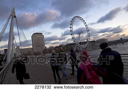 Stock Image - Pedestrians crossing the Golden Jubilee Bridge, River Thames; London, England. Fotosearch