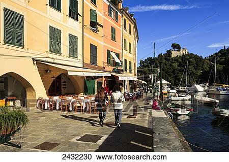 Stock Image - Pedestrians on a promenade along the harbour; Portofino, Liguria, Italy. Fotosearch