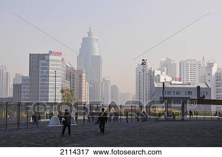 Stock Photo - Pedestrians On A Walkway With Buildings In An Urban Area; Beijing China. Fotosearch