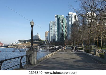 Pedestrians on the promenade along the water's edge with condominium buildings along the waterfront; Vancouver, British Columbia, Canada View Large Photo Image Stock Image - Pedestrians on the promenade along the water's edge with condominium buildings along the waterfront; Vancouver, British Columbia, Canada. Fotosearch