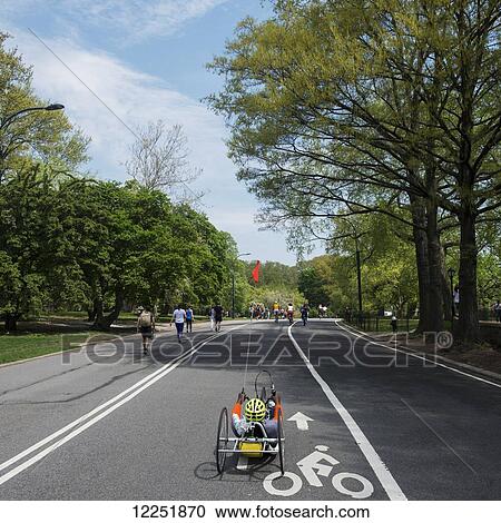Stock Image - Pedestrians, runners and cyclists on a park path; New York City, New York, United States of America. Fotosearch