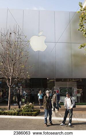 Stock Image - Pedestrians standing outside a technology retail store; California, United States of America. Fotosearch