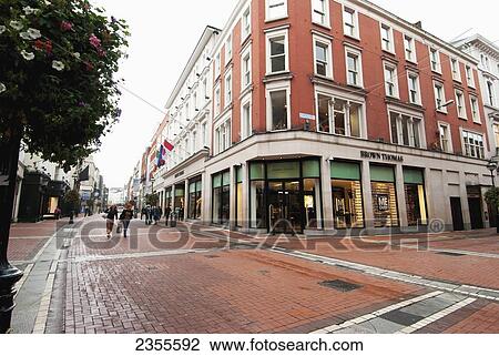 Stock Image - Pedestrians Walk By A Building On The Corner In Temple District; Dublin, Ireland. Fotosearch