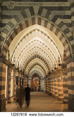 Pedestrians walk down an arched corridor with striped black and white facade; Genoa, Liguria, Italy View Large Photo Image Stock Photo - Pedestrians walk down an arched corridor with striped black and white facade; Genoa, Liguria, Italy. Fotosearch