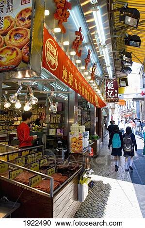 Stock Image - Pedestrians Walking Along Food Stall. Fotosearch