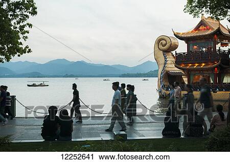 Pedestrians walking around the famous West Lake; Hangzhou, China View Large Photo Image Stock Image - Pedestrians walking around the famous West Lake; Hangzhou, China. Fotosearch
