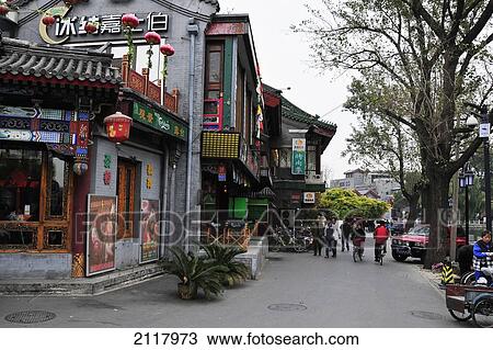 Stock Image - Pedestrians Walking By Buildings On A Street; Beijing China. Fotosearch