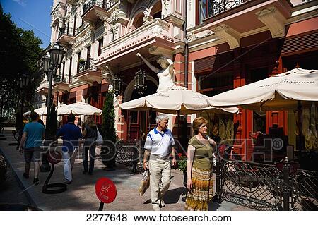 Stock Photo - Pedestrians walking by historic buildings in Odessa City Centre; Odessa, Ukraine. Fotosearch